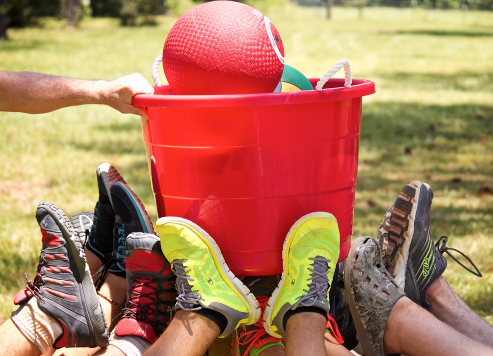 Feet holding bucket of balls